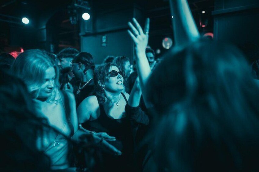 Una multitud de personas en un concierto, con las manos levantadas y una iluminación azulada. 4