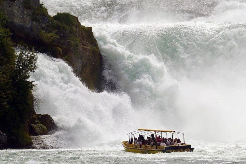 A boat with passengers navigating a turbulent waterfall. 2