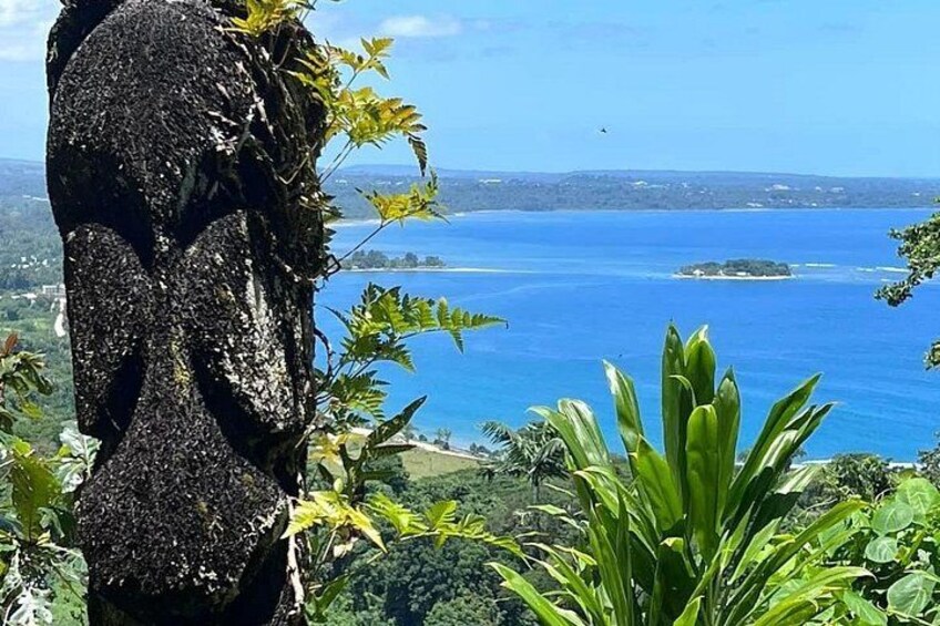 Ein felsiges Vorsprungsbild mit Vegetation, tiefblauem Meer und einer fernen Küstenlinie. 5