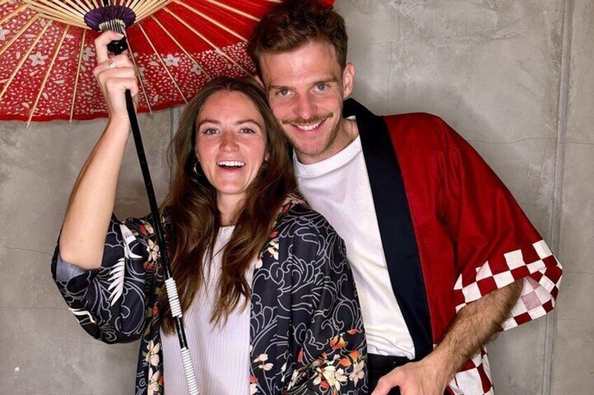 A person holding a fan and wearing a patterned jacket. 3