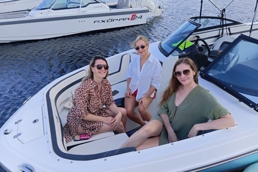 Three people on a small boat with a wake behind it, indicating movement through water. 5