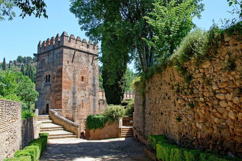 Un castillo de piedra con una torre, un muro de piedra y un camino que lleva al castillo. 2