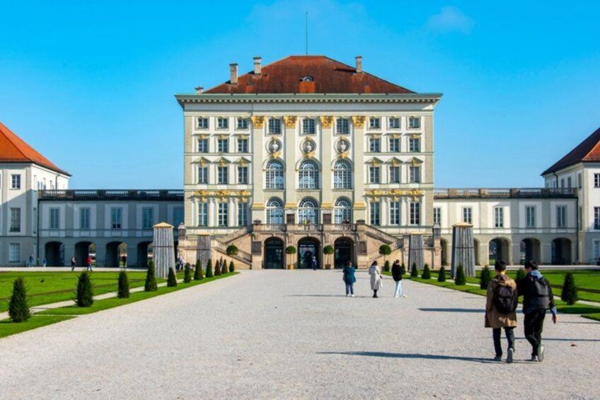 Un grand bâtiment historique doté d’une entrée centrale, entouré d’un jardin symétrique et de bâtiments plus petits. 5