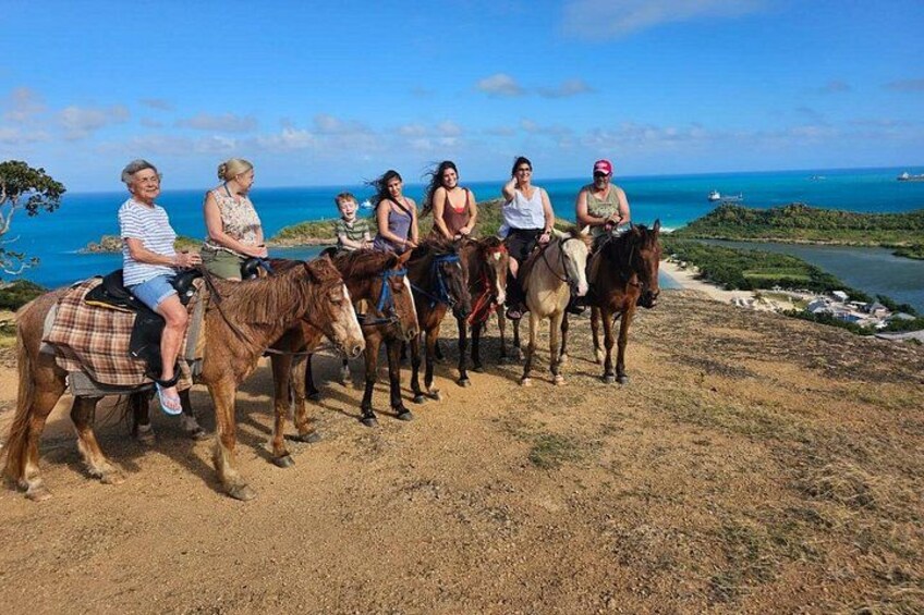 Un groupe de personnes à cheval, évoluant sur un chemin de terre avec une vue sur la côte. 2