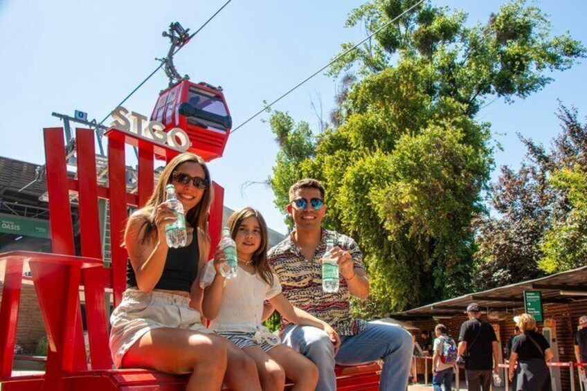 Una sedia rossa con una persona seduta, un cartello rosso con la scritta 'STEO' e una funivia sullo sfondo. 1