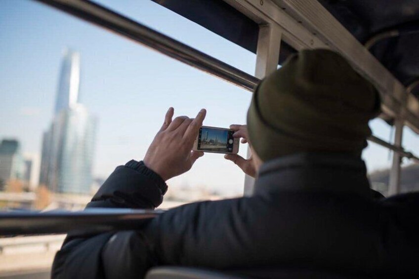 Una persona che fotografa una veduta urbana con un grattacielo sullo sfondo. 5