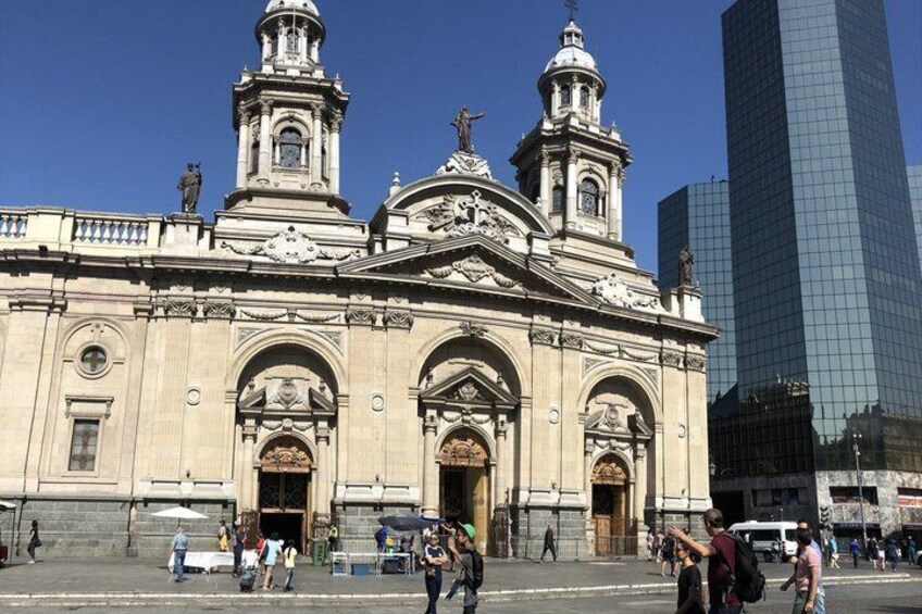 Una chiesa storica con due torri e un grattacielo moderno sullo sfondo. 4