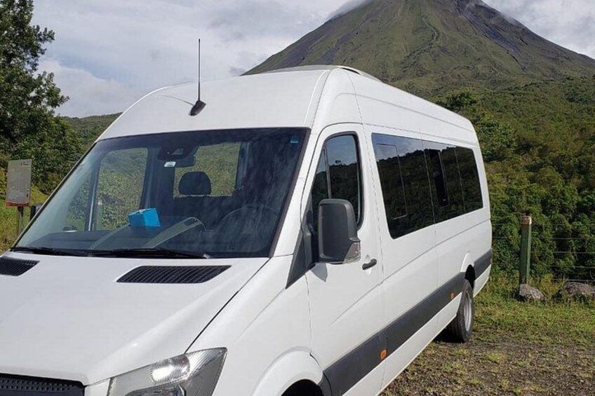 A white van parked on a grassy area with a mountainous background. 2