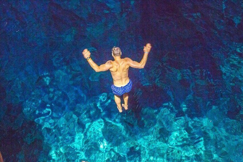 A person diving into clear blue water. 3