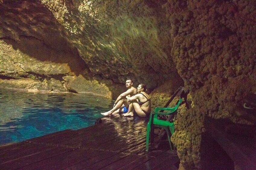 A natural swimming pool with people sitting on a wooden deck. 2