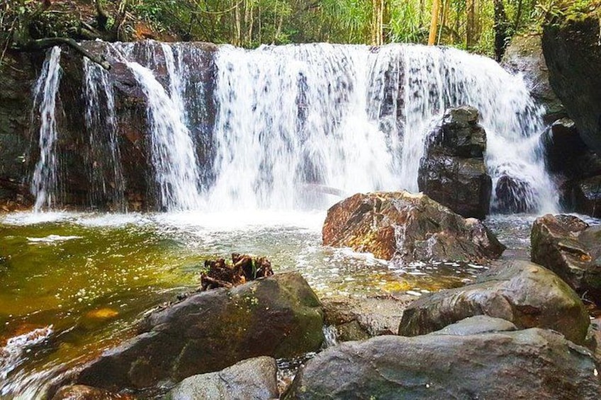 A waterfall cascading over rocks in a forested area. 3