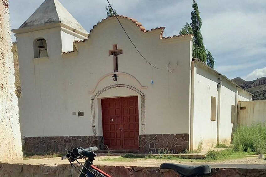 Une petite église avec une porte rouge et une croix au-dessus. 2