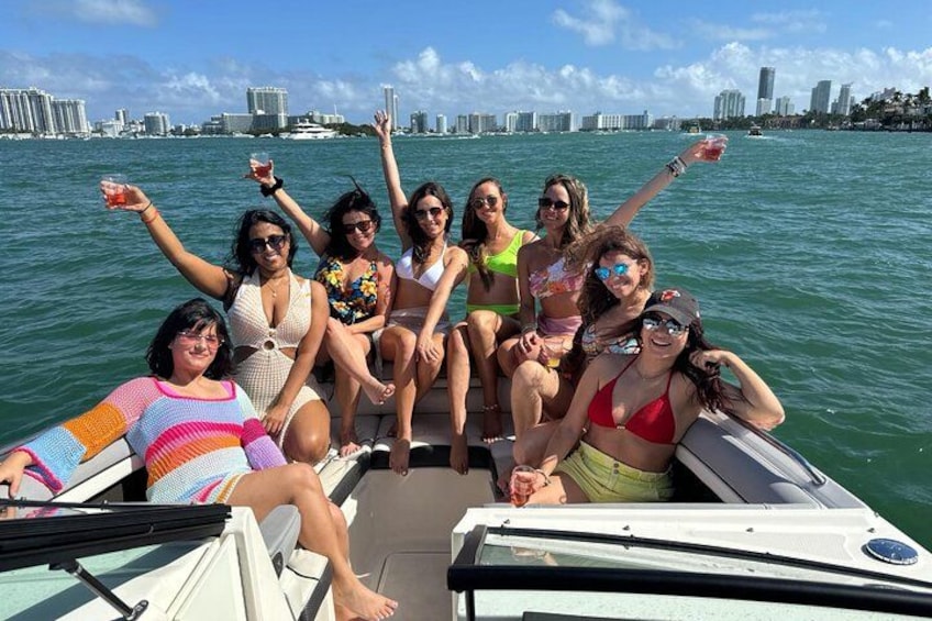 A group of people on a boat with a city skyline in the background. 3