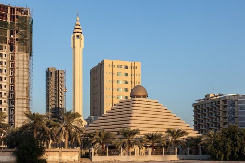 A cityscape with a prominent mosque, palm trees, and modern buildings. 5
