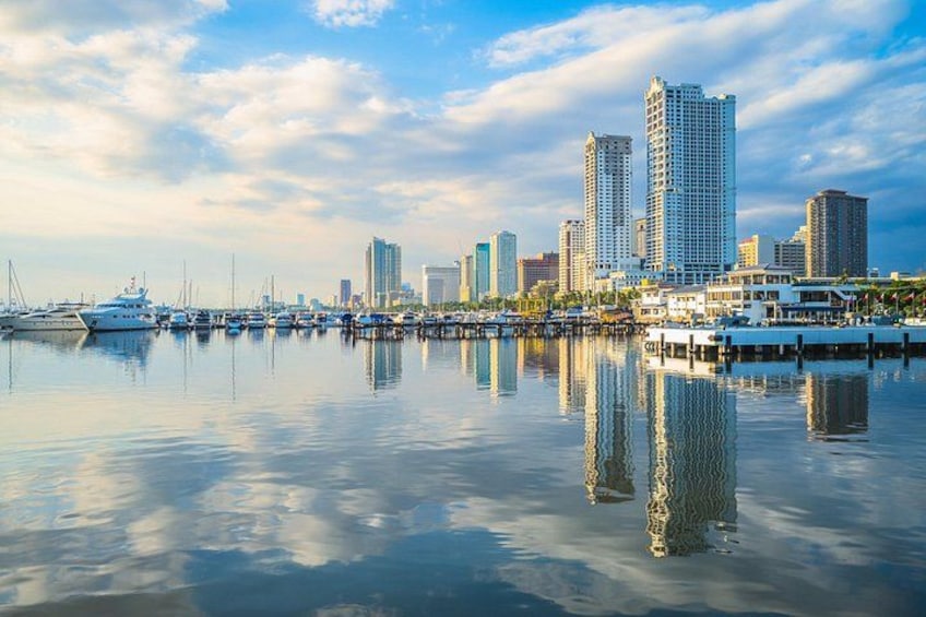 A marina with boats, a waterfront, and a city skyline with high-rise buildings. 4