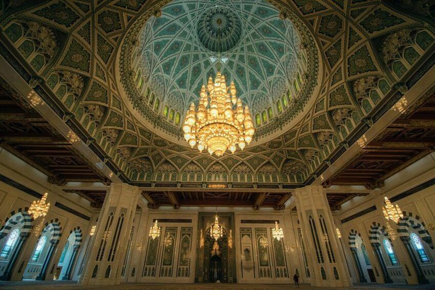 Un interior ornamentado con un gran techo abovedado, diseños intrincados y un candelabro central. 3