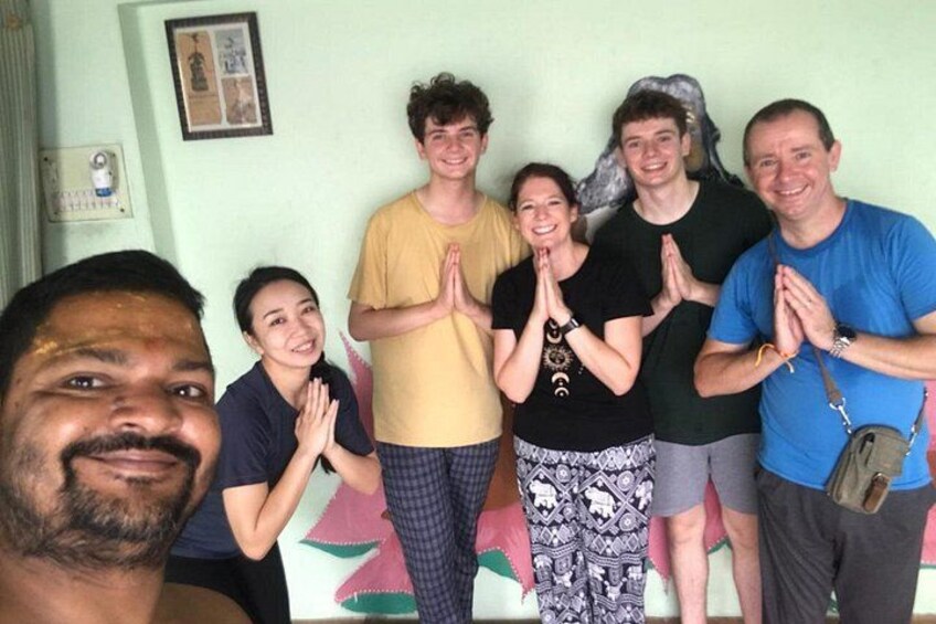 A group of people standing indoors with their hands together. 5
