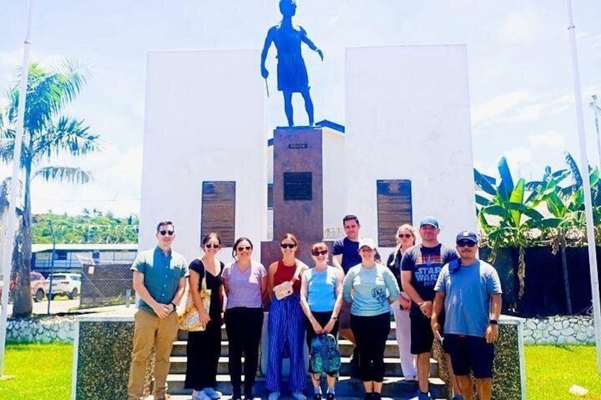 A group of people standing in front of a large sculpture. 2