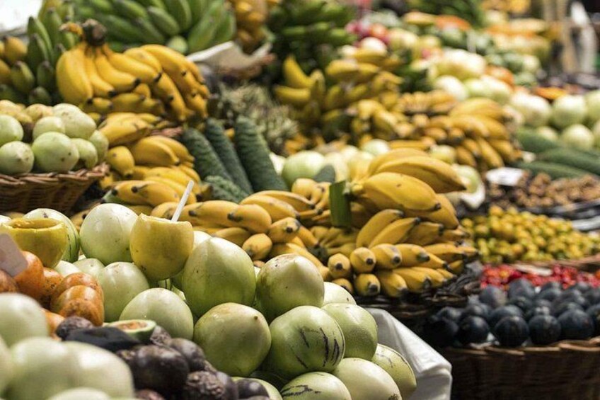 En marknad med ett varierat utbud av frukter, som bananer, äpplen och apelsiner. 1