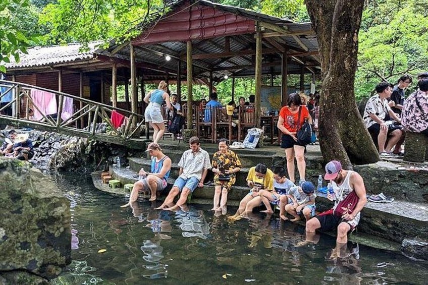 People relaxing by a water body, a wooden structure, and a bridge. 3