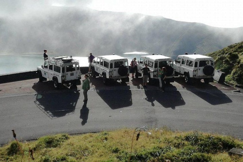 Quattro veicoli fuoristrada bianchi parcheggiati su una strada con montagne sullo sfondo. 4