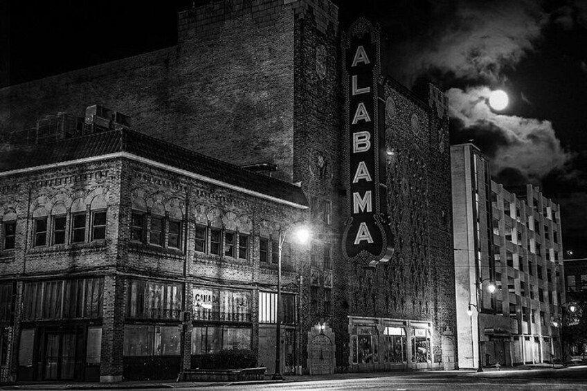 A historic theater with a marquee reading 'ALABAMA' and a full moon in the background. 3