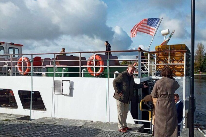 A boat with lifebuoys, an American flag, and people boarding. 1
