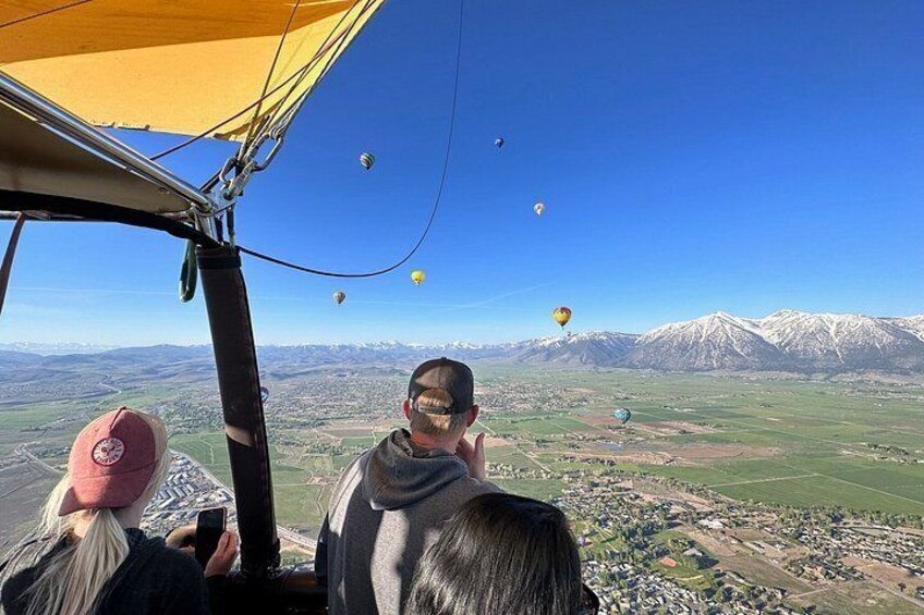 Vuelo en globo aerostático con pasajeros observando el paisaje de abajo. 4