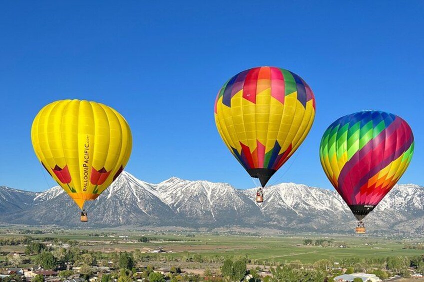 Tres globos aerostáticos sobre un paisaje montañoso. 1
