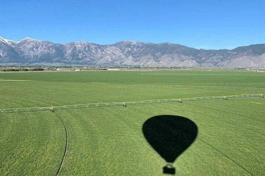 Un extenso campo verde con montañas al fondo. 5