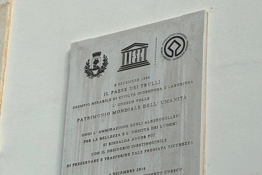 A plaque with text and logos on a wall. 2
