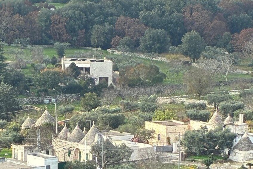 A rural landscape with traditional stone houses, a stone building, and a hilly backdrop. 4