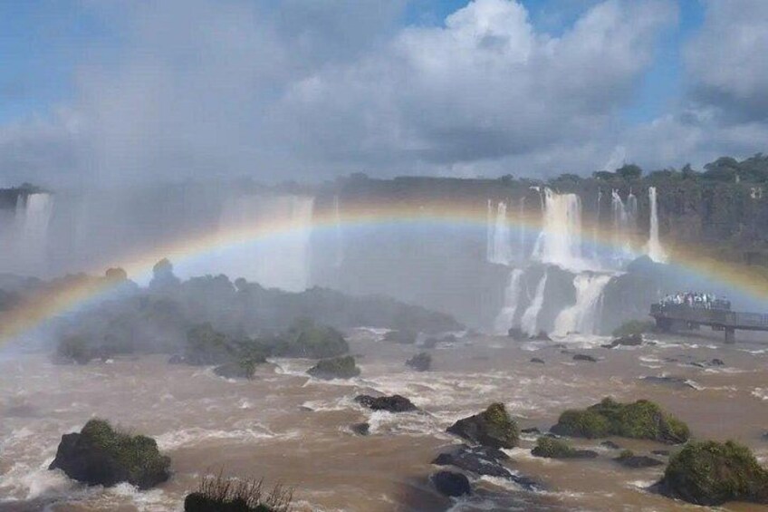 Una cascata con un arcobaleno, terreno roccioso e una piattaforma panoramica. 4