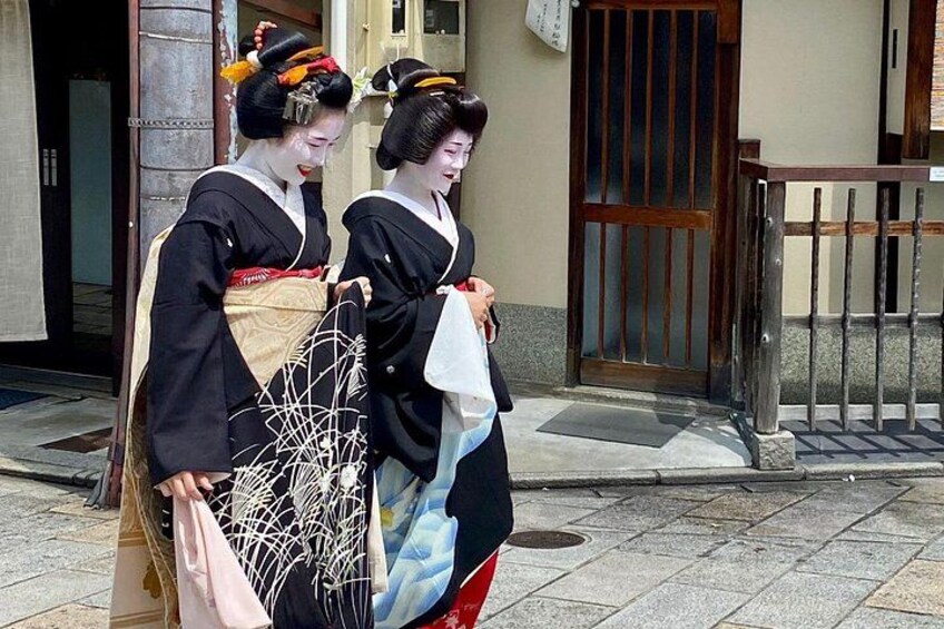 Two women in traditional Japanese attire walking on a street. 2