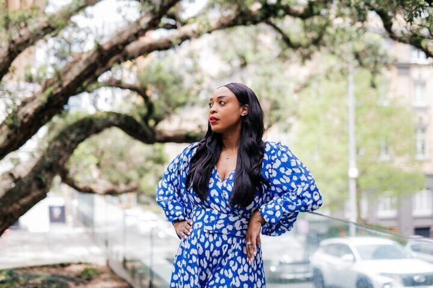 A person in a blue dress with white patterns standing outdoors. 5
