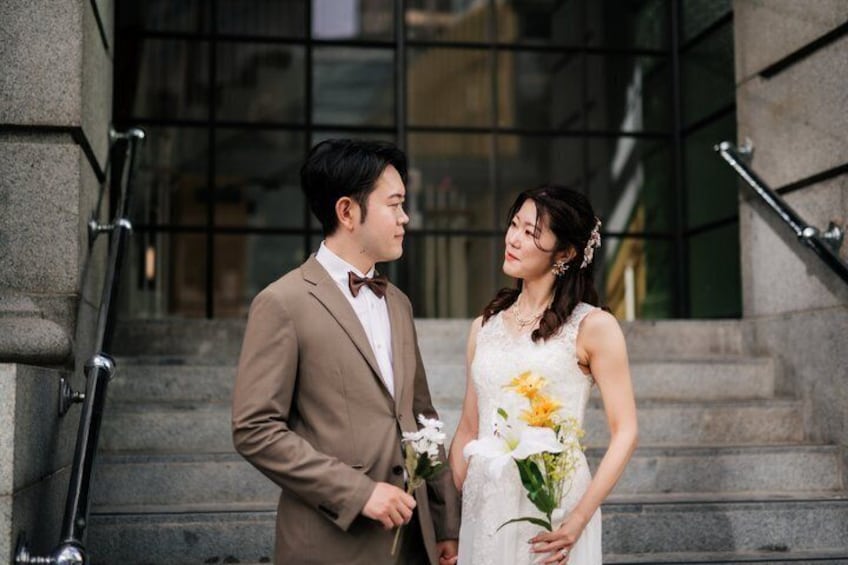 A couple on a staircase with a building in the background. 2
