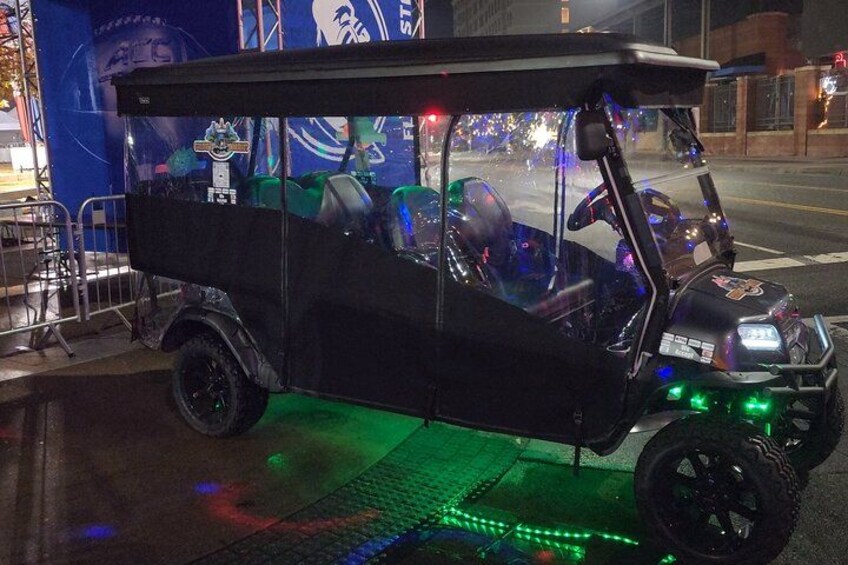 Un carrito de golf negro con luces LED verdes en el suelo. 4