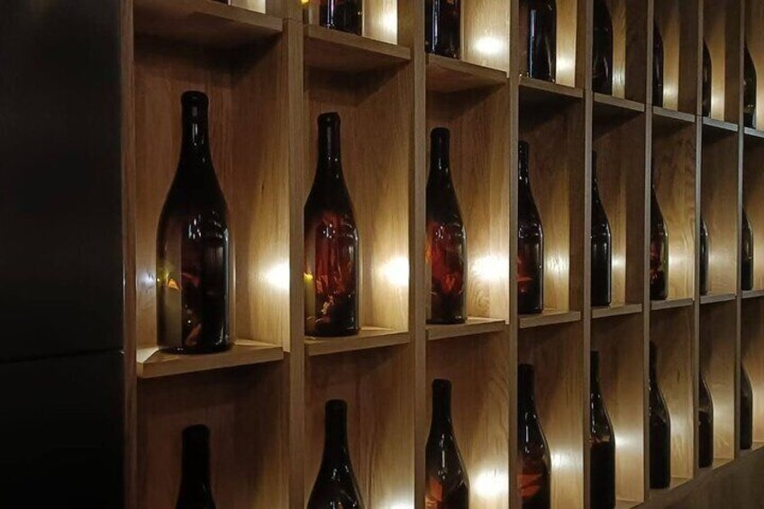 Uno scaffale di legno con diverse bottiglie di vino. 5