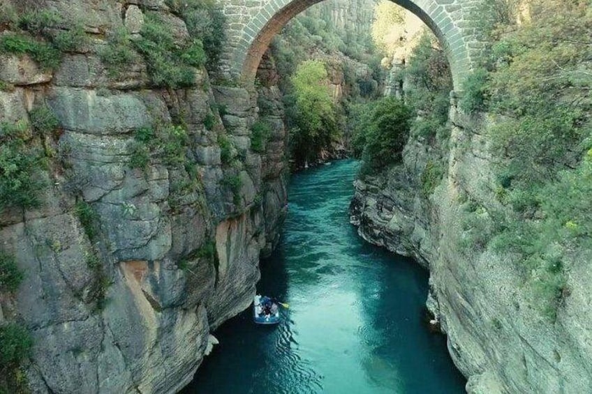 A river under a stone bridge with a boat. 4