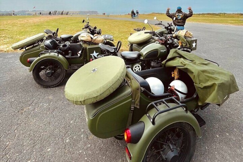 Una motocicleta militar antigua con sidecar, estacionada sobre una superficie pavimentada. 5