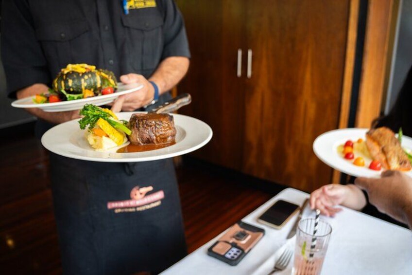 A waiter serving food at a restaurant table. 4