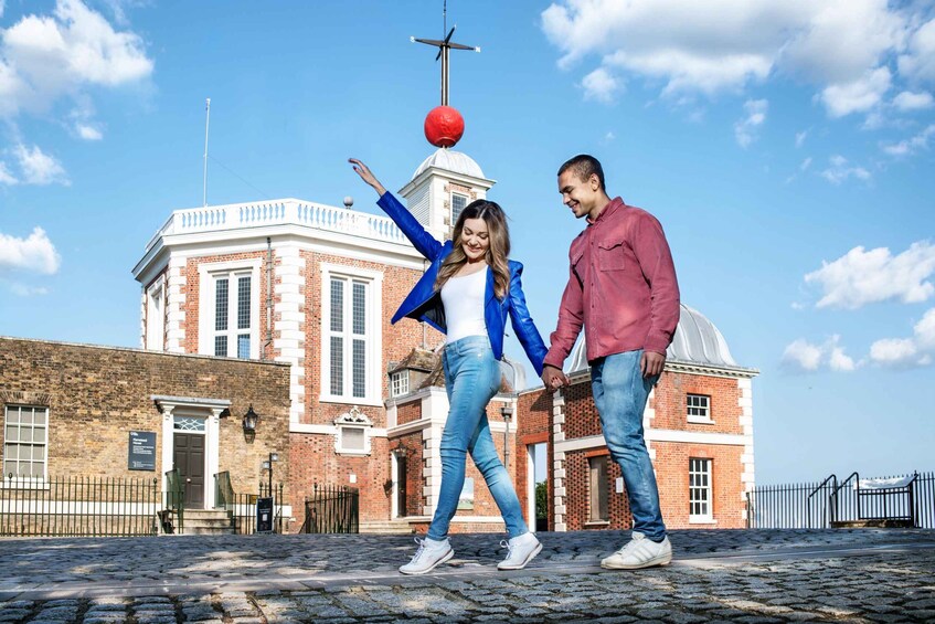 Una pareja tomándose de las manos frente a un edificio histórico con una cúpula y una esfera roja en la parte superior. 4