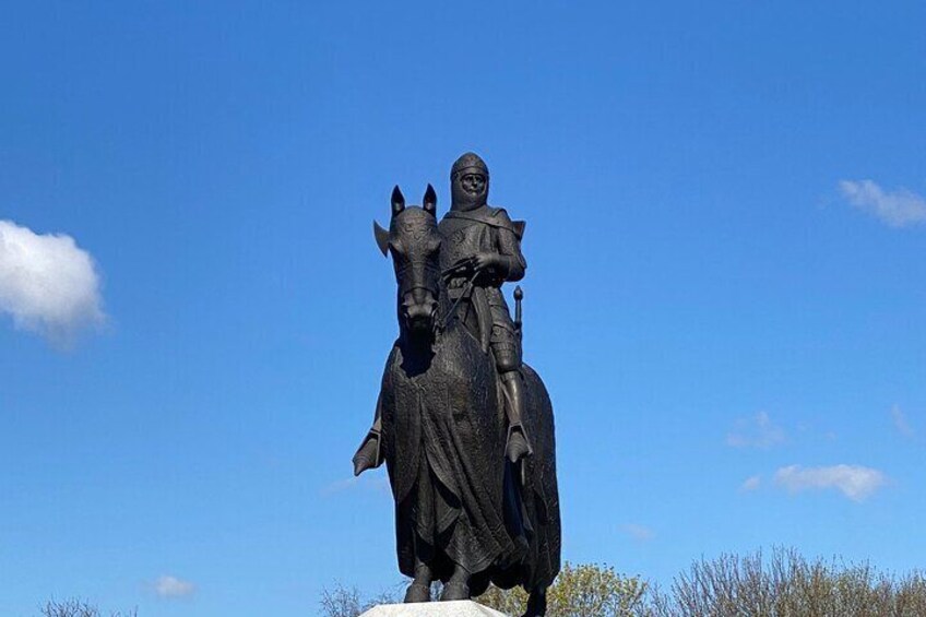 A statue of a man on horseback under a clear blue sky. 3