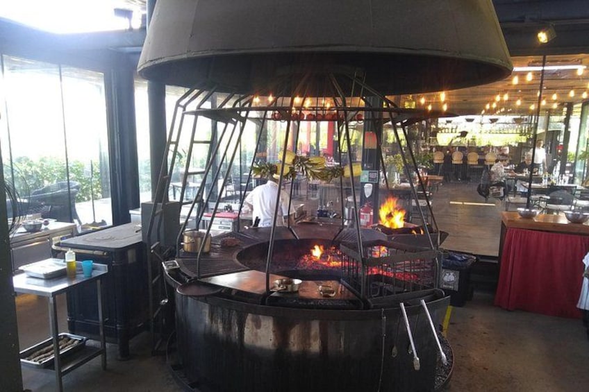 Een buitenkeuken met een grote grill en een kok die eten bereidt. 5