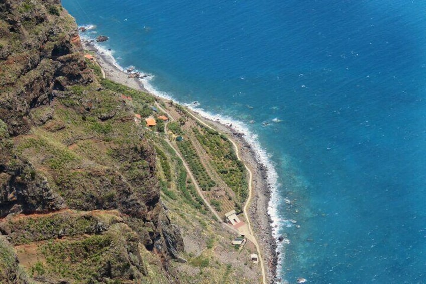 A coastal landscape with a winding road, rocky cliffs, and a beach. 5