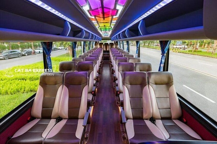 A train interior with rows of seats, a central aisle, and windows. 3