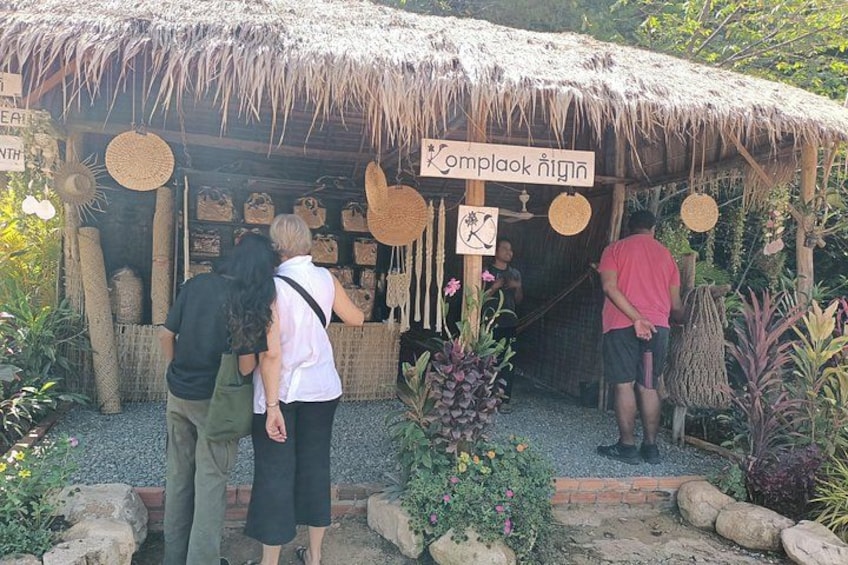 A thatched-roof structure with woven baskets and a sign reading 'Complok ngin'. 4