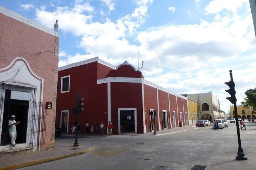 A street with a red building, a traffic light, and a pedestrian crossing. 2