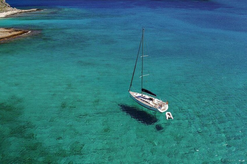 A sailboat anchored in clear turquoise waters. 2