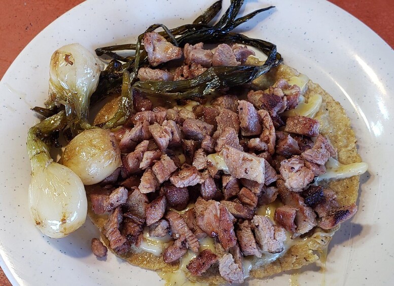 A plate of food with grilled meat, onions, and seaweed. 2